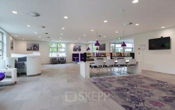 Spacious reception area in an office building at Newtonlaan 115, Utrecht Rijnsweerd, featuring modern furnishings and vibrant decor.
