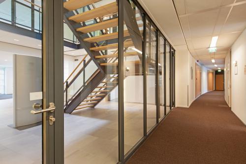 Interior corridor of an office to rent at Newtonlaan 115, Utrecht Rijnsweerd, with a staircase and modern office decor.