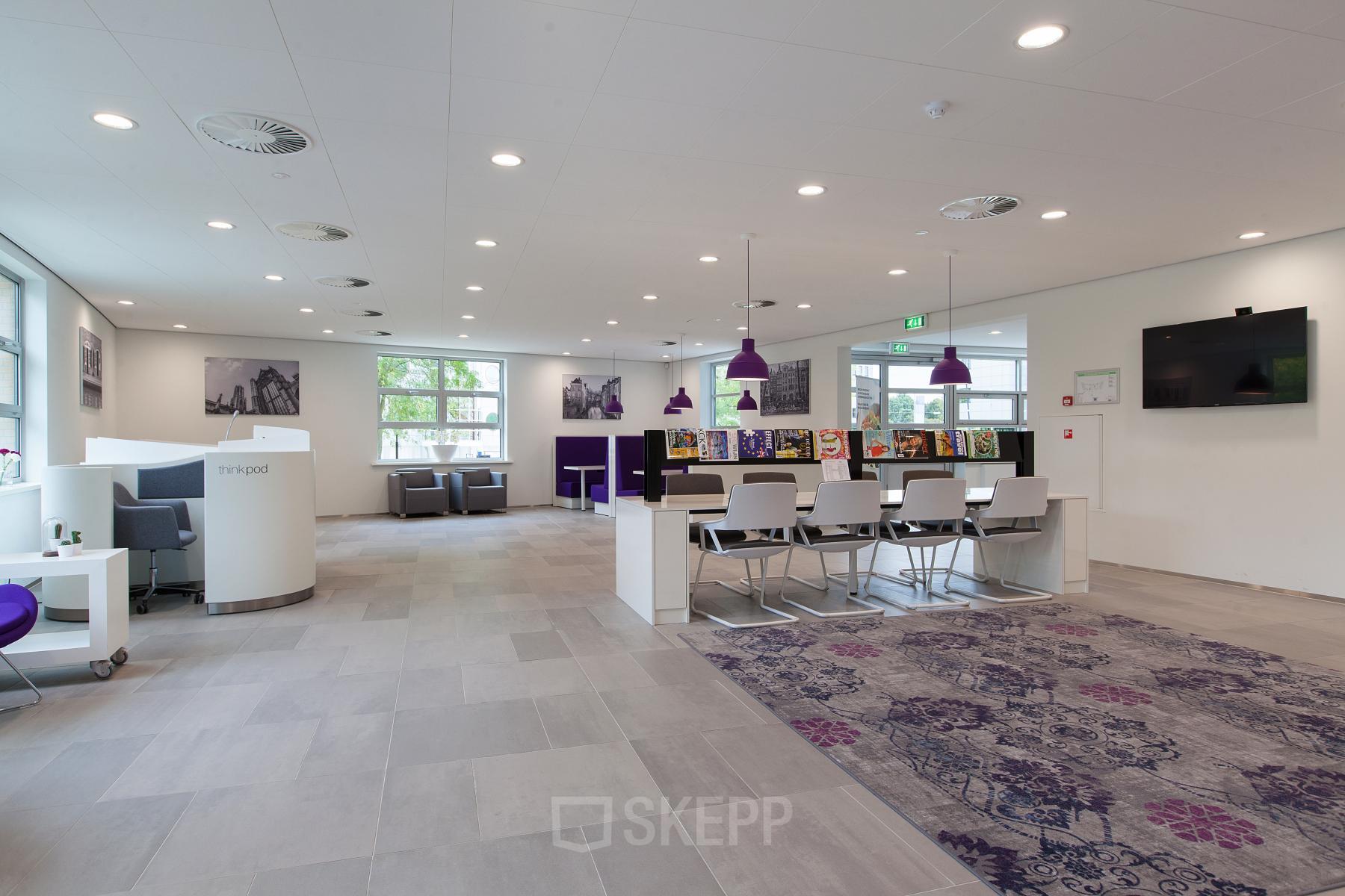 Spacious reception area in an office building at Newtonlaan 115, Utrecht Rijnsweerd, featuring modern furnishings and vibrant decor.