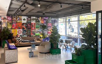 Vibrant office space at Daltonlaan 200, Utrecht Rijnsweerd, featuring cozy seating, lush plants, and colorful wall posters, perfect for office space rental.