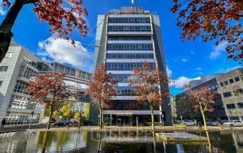 Exterior view of an office building at Daltonlaan 200 in Utrecht Rijnsweerd, featuring a clear sky and autumn trees. Ideal for businesses seeking office space rental.
