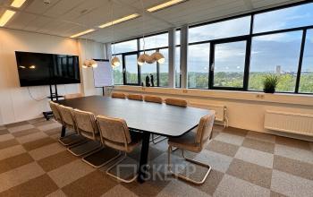 Modern office space with a large conference table and chairs, located at Daltonlaan 200, Utrecht Rijnsweerd, ideal for office space rental with a view of the cityscape through large windows.