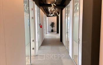 Hallway with office spaces available for rent at Daltonlaan 200, Utrecht Rijnsweerd. Bright lighting and modern design make it ideal for office space rental.
