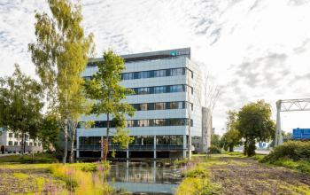 Modern office building at Euclideslaan 51, Utrecht Rijnsweerd, featuring a sleek glass facade surrounded by nature. Ideal for office space rental.