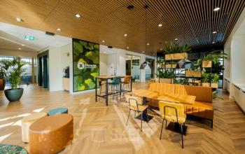 Modern office space in Utrecht Rijnsweerd at Euclideslaan 51 featuring stylish furnishings, green walls, and ample natural light, ideal for workspaces. Perfect spot for office space rental.