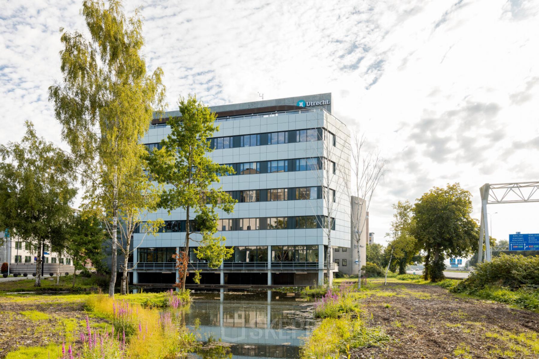 Modern office building at Euclideslaan 51, Utrecht Rijnsweerd, featuring a sleek glass facade surrounded by nature. Ideal for office space rental.