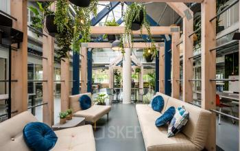 Modern and vibrant office space rental at Weg der Verenigde Naties 1, Utrecht featuring cozy seating areas and lush greenery.