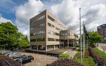 Modern office building at Weg der Verenigde Naties 1 in Utrecht, showcasing an available office to rent with ample parking space.