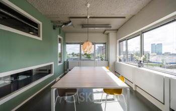 Modern Utrecht office space rental at Weg der Verenigde Naties 1 with a sleek wooden table, comfortable seating, and ample natural light.