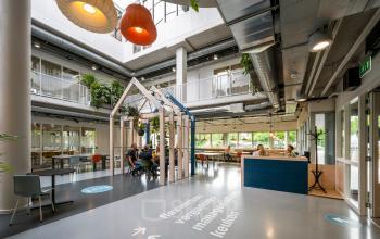 Modern office space rental at Weg der Verenigde Naties 1, Utrecht, featuring a stylish interior with ample natural light and communal work areas.
