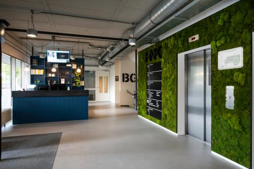 Modern office space rental at Weg der Verenigde Naties 1, Utrecht, showing a sleek reception area with stylish furnishings and vibrant green wall accents.