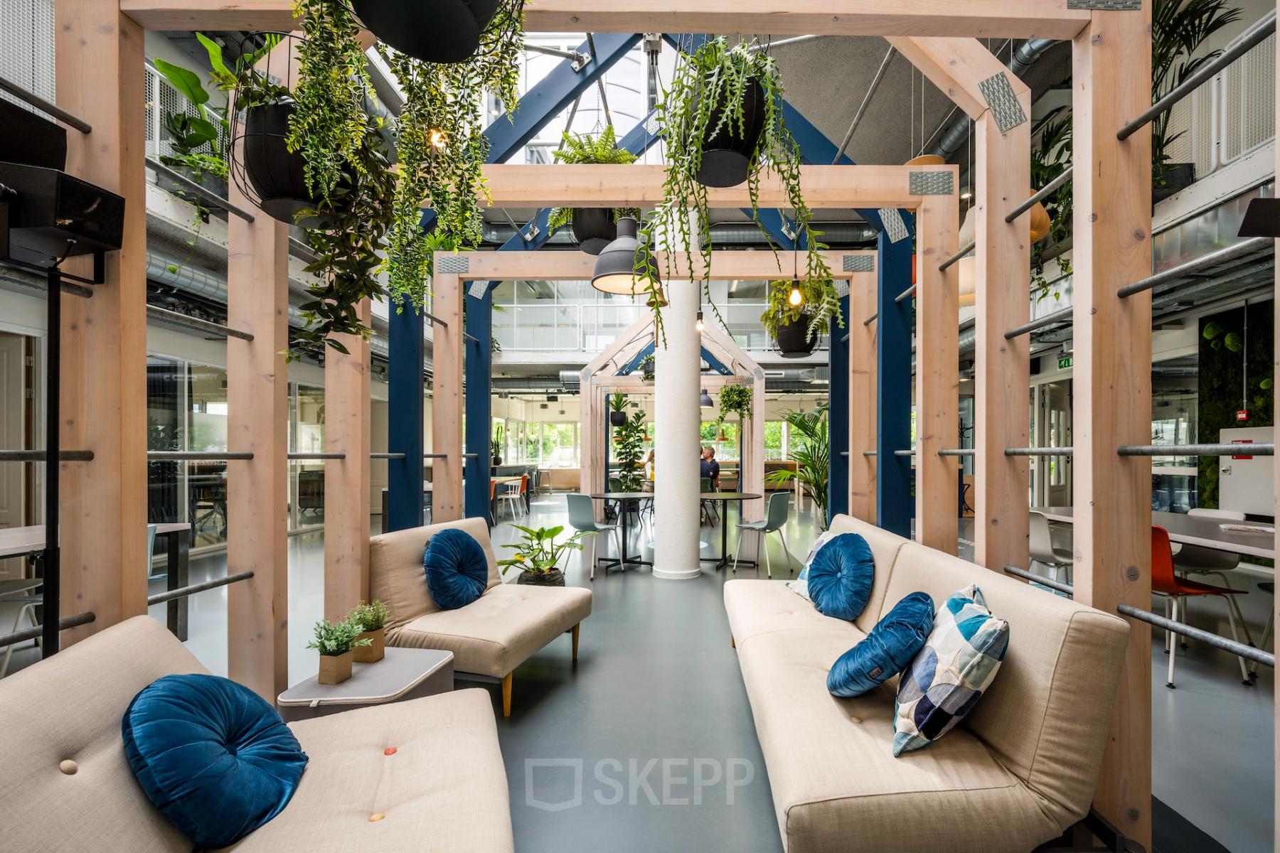 Modern and vibrant office space rental at Weg der Verenigde Naties 1, Utrecht featuring cozy seating areas and lush greenery.