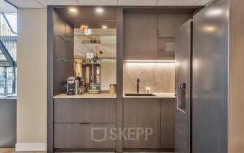 Modern kitchenette in an office space on Niasstraat 1, Utrecht West, featuring sleek cabinets and appliances, ideal for a quick coffee break. Explore office space rental in this convenient location.