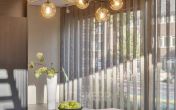 Modern interior of an office at Niasstraat 1 1, Utrecht West, featuring stylish pendant lighting and a marble island with seating, available for office space rental.