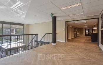 Spacious interior with herringbone flooring at Niasstraat 1, Utrecht West, showcasing natural light and modern design, ideal for office space rental.