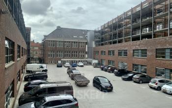Exterior view of office building located at Niasstraat 1, Utrecht West, showcasing ample parking space available for office space rental.