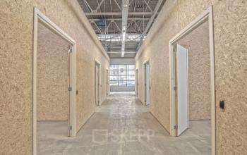 Interior corridor with multiple wooden doors leading to office spaces for rent at Eendrachtlaan 100-260, Utrecht South.