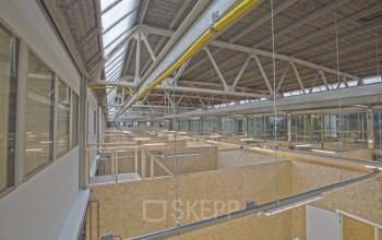 Industrial-style office space at Eendrachtlaan 100-260, Utrecht South, featuring high ceilings with exposed beams and partitions, perfect for businesses seeking unique office space rental options.