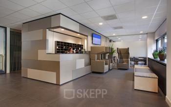 Modern reception area at Winthontlaan 200, Utrecht South, with a professional at the desk handling office space rental inquiries.