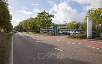 View of office building available for office space rental at Winthontlaan 200, Utrecht Zuid with parking lot and signage.