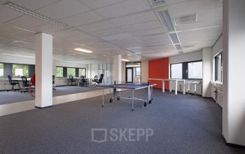 Spacious and well-lit office space rental at Winthontlaan 200 in Utrecht South, featuring modern furniture and a vibrant color accent wall.