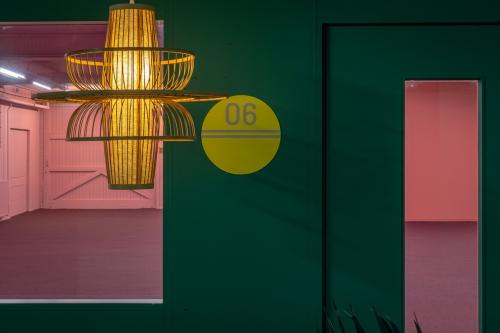 Vibrant interior view of office space rental at Vrieslantlaan 6, Utrecht South. Features green and pink decor with a modern light fixture, ideal for creative workspaces.