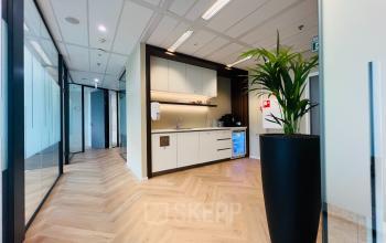 Interior view of modern office space with kitchenette and plant at Vliegend Hertlaan 15, Utrecht South, ideal for office space rental.
