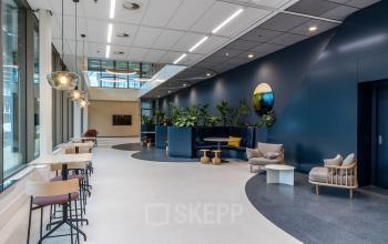Modern office located at Vliegend Hertlaan 15, Utrecht South, with stylish furnishings including seating areas and lush greenery, ideal for office space rental.