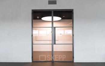 Modern office entrance at Churchilllaan 11, Utrecht South, featuring sleek glass doors and minimalist design ideal for office space rental inquiries.
