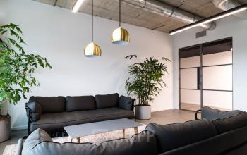 Modern lounge area in the Churchilllaan 11 office building in Utrecht South, featuring comfortable seating and plants.