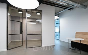 Modern office interior at Churchilllaan 11, Utrecht South, featuring sleek glass doors and contemporary lighting, perfect for office space rental.