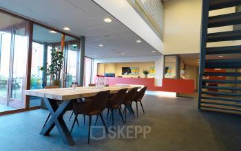 Spacious office interior at Kerkhofstraat 21, Valkenswaard, with a large conference table and modern decor, suitable for office space rental.