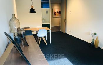 Bright office space rental at Kerkhofstraat 21, Valkenswaard with modern furniture, wall art, and a neat carpet.