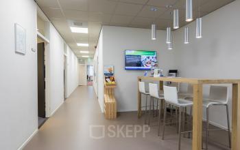 Modern office space interior at Costerweg 5, Veghel, featuring a sleek communal area with a high table and stools, ideal for collaboration. Consider this office space rental for a productive work environment.