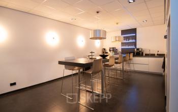 Modern office space rental at Gildestraat 13, Velp, featuring a sleek interior with high stools and a coffee area, perfect for informal meetings.