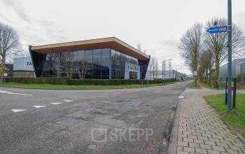 Exterior view of the office building at Gildestraat 13, Velp, featuring large glass windows and modern architecture, ideal for office space rental.