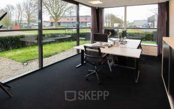Corner office space to rent at Gildestraat 13, Velp, featuring large windows, desks, and chairs, suitable for business activities.