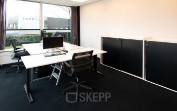 Modern office space at Gildestraat 13 in Velp with sleek desks, chairs, and a window view, ideal for rental.