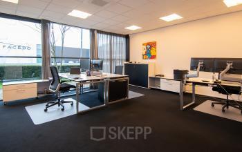 Modern office space rental at Gildestraat 13, Velp, featuring spacious desks and large windows with natural light.