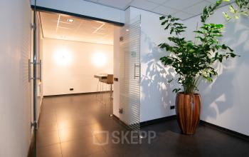 Modern office space at Gildestraat 13, Velp featuring a sleek entrance with glass door and large plant, available for office space rental.