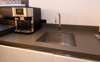 Kitchen area with a sleek counter and modern coffee machine at office space rental in Velp.