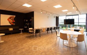 Bright office space available for rent on Gildestraat 13, Velp, featuring modern seating and a large window, ideal for workspaces.