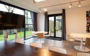 Spacious office space rental at Gildestraat 13, Velp with modern furnishings, large windows, and a welcoming atmosphere. Ideal for meetings and collaboration.