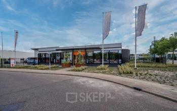 Exterior view of office space rental at Noorderpoort 43, Venlo, featuring a modern building with large windows and surrounding greenery.