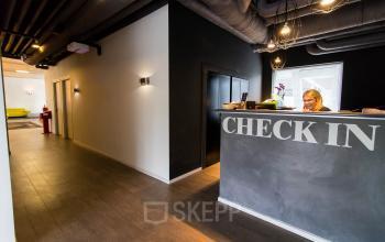Reception area at Kaldenkerkerweg 20, Venlo with a staff member checking in visitors. This inviting space is part of the available office space rental.