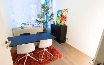 Furnished office space with modern decor, featuring a table, chairs, and bright artwork at Kaldenkerkerweg 20 in Venlo for office space rental.