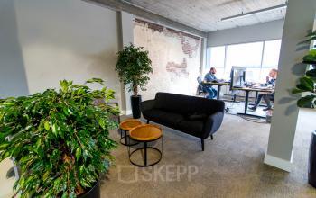 Modern office space at Kaldenkerkerweg 20, Venlo, featuring workstations with computers, plants, and a seating area. Ideal for those seeking office space rental.