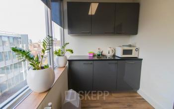 Bright office pantry at Kaldenkerkerweg 20, Venlo, featuring modern cabinets and appliances, perfect for your office space rental needs.