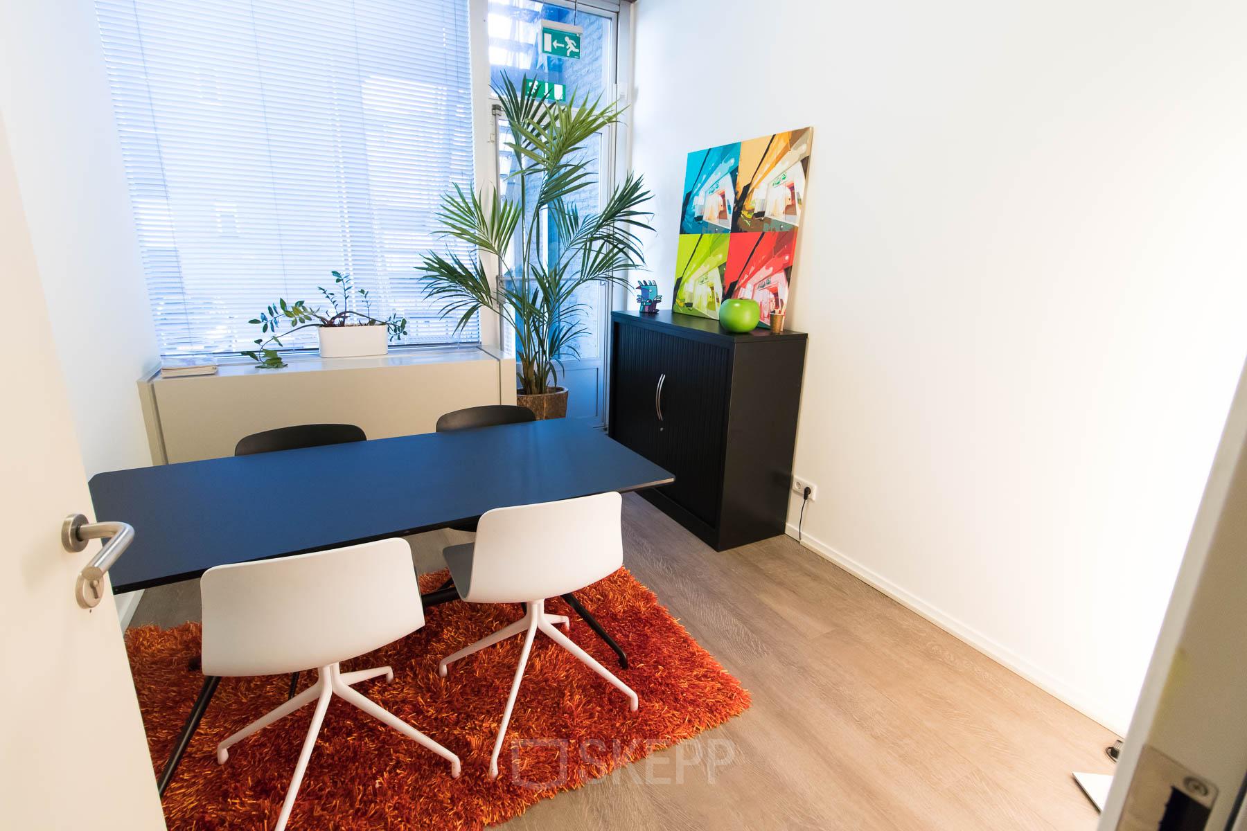 Furnished office space with modern decor, featuring a table, chairs, and bright artwork at Kaldenkerkerweg 20 in Venlo for office space rental.