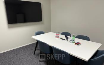 Modern conference room at Noorderpoort 33 33, Venlo, featuring a large screen and a table with chairs, ideal for office space rental.